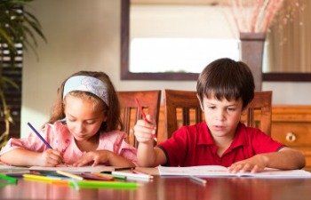 kids doing homework at kitchen table