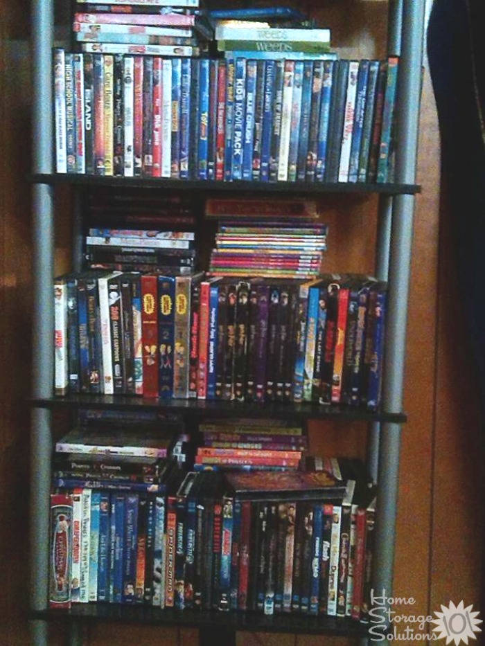 Cluttered bookshelf with excess DVDs that needs to be decluttered {featured on Home Storage Solutions}