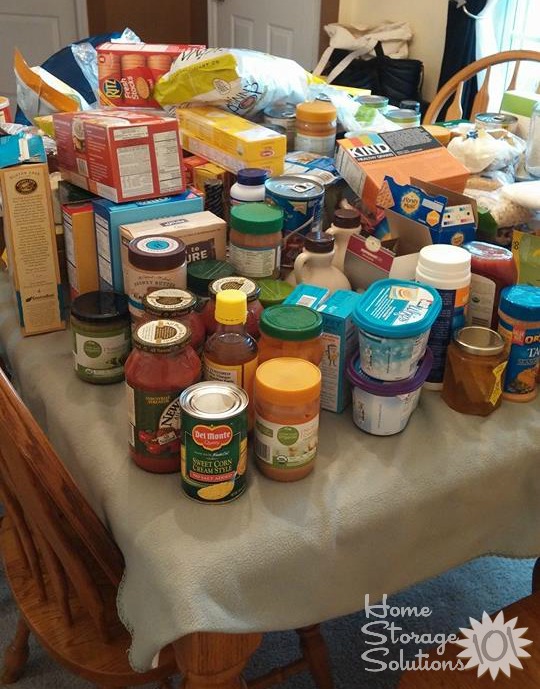 Food all pulled from the pantry and placed onto kitchen table for sorting and decluttering {featured on Home Storage Solutions 101} Food all pulled from the pantry and placed onto kitchen table for sorting and decluttering {featured on Home Storage Solutions 101}