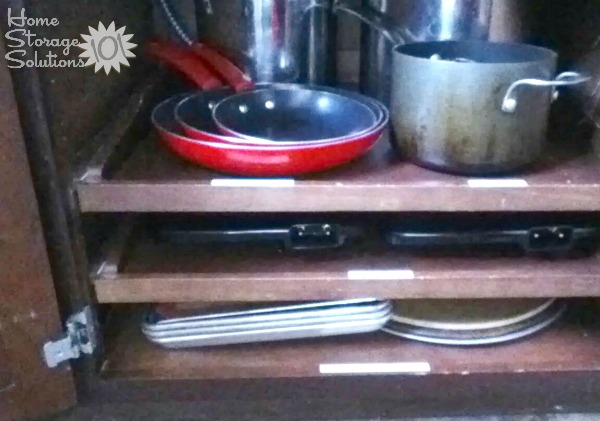 Slide out kitchen shelves in cabinets for storing pots and pans, with labeled shelves {featured on Home Storage Solutions 101}