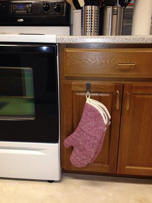 Domestic kitchen towels and tea cloths, and oven gloves, hanging