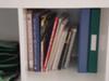 Organized cookbooks and recipe binders on shelf