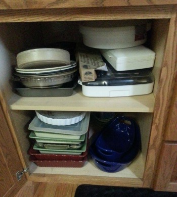 stacked bakeware in cabinet