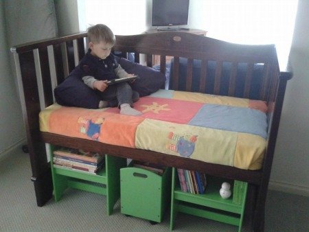 repurposed baby crib turned into reading nook